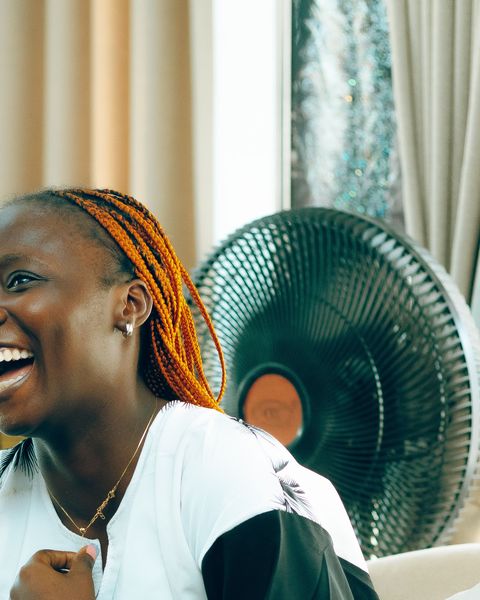 A young woman laughing joyfully with friends at home